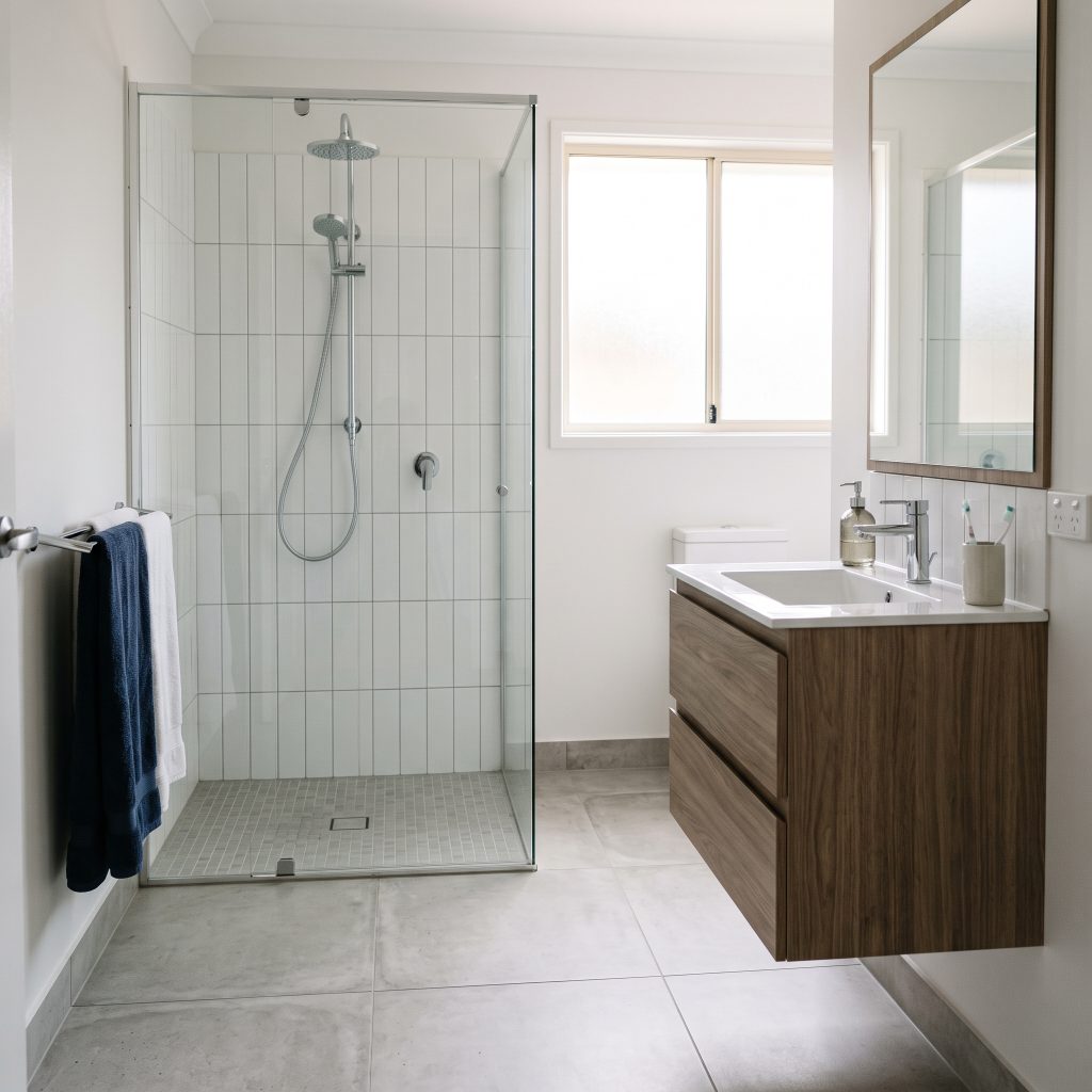 Bathroom with frameless glass shower and timber vanity