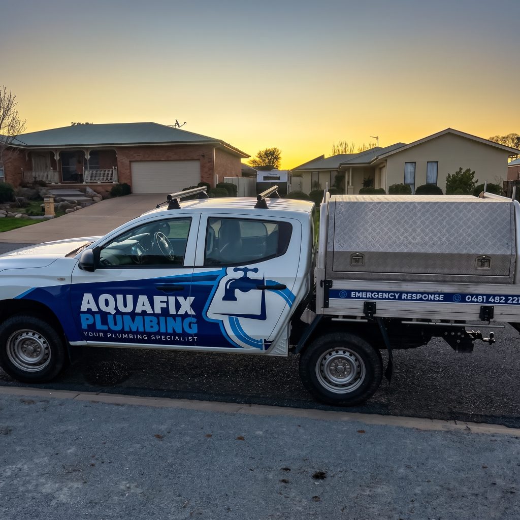 Aquafix Plumbing ute parked outside a home at sunset